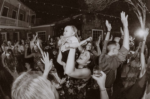 A woman holds up her baby during the shout part of the shout song as the crowd dances at Broussard’s - Julia Bailey 
