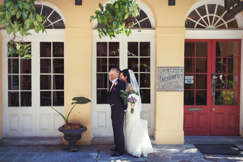 A bride approached from behind to place a hand playfully over her smiling fiance's eyes during thier first look - Julia Bailey