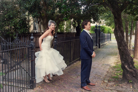 A man stands facing away from his bride as she approaches for their first look of the day - Julia Bailey