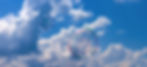 Seifenblasen vor blauem Himmel mit Wolken