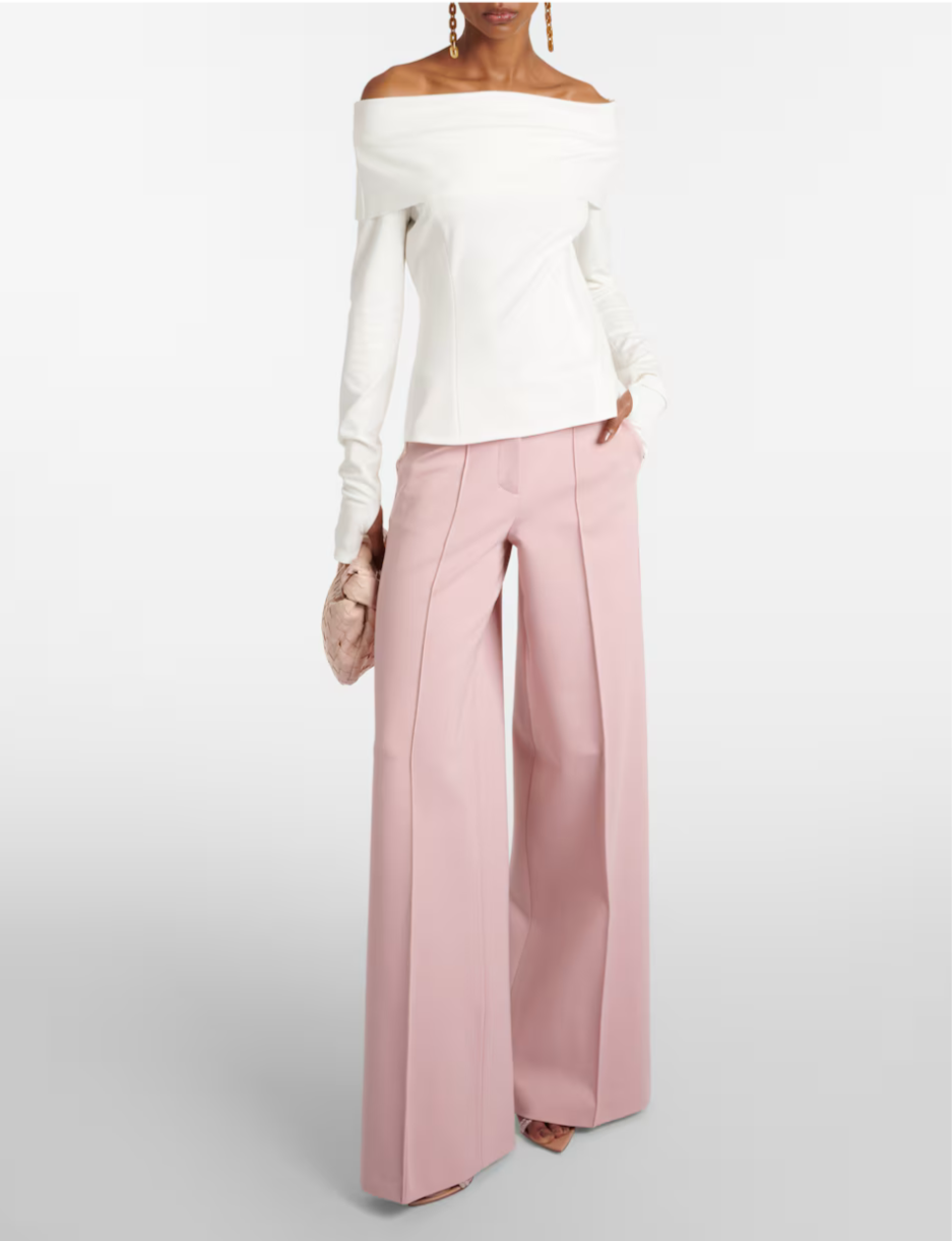 Woman in a white off-the-shoulder top and pink wide-leg trousers