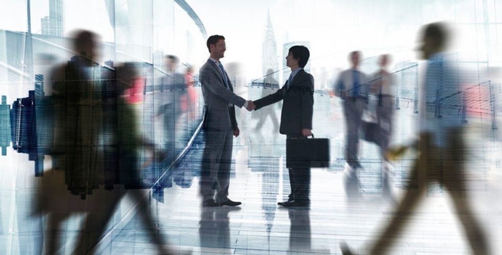Due professionisti si stringono la mano in un ufficio moderno per siglare un accordo di networking professionale a Lugano.