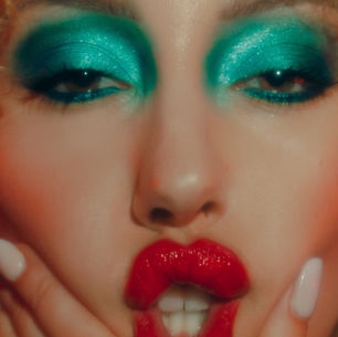 Editorial beauty makeup with vibrant turquoise eyeshadow and glossy red lips. Creative beauty makeup by Detroit makeup artist Nico Cortes.