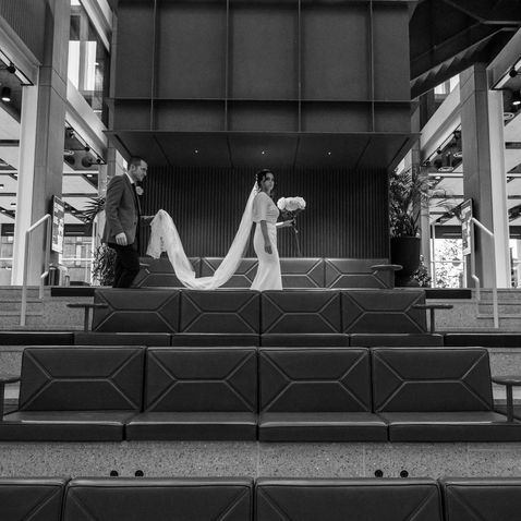 The newlyweds holding hands on a staircase at City Hall