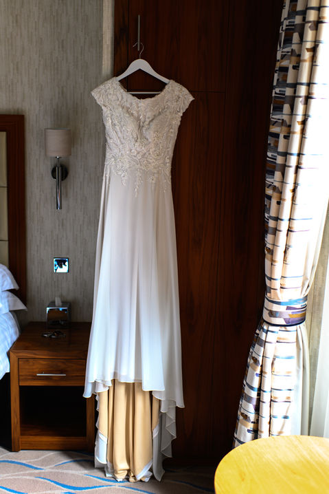 Wedding dress hanging beside a window — SHAUN and SAM wedding