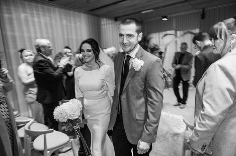 Black and white photograph of the newlyweds walking back down the aisle