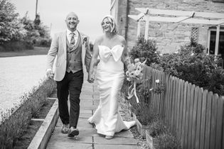 A black and white photograph of the couple walking beside the farmhouse at Northside Farm, Northumberland