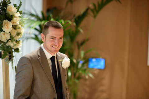 A smiling wedding guest wearing a buttonhole