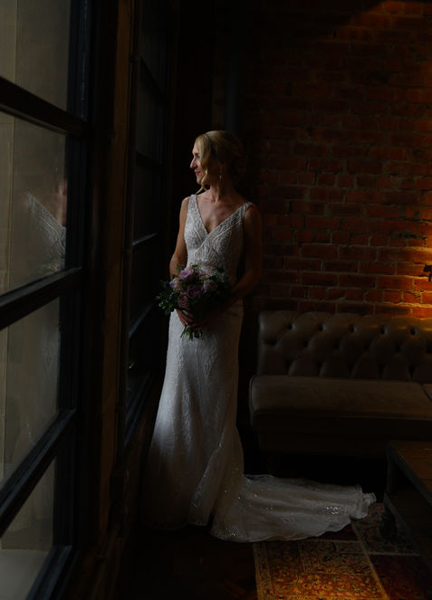 The bride holding her bouquet in window light — OL and JULIE wedding