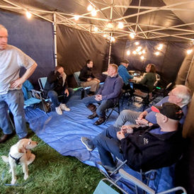 Members chatting before their turn operating, Molly the dog awaiting her sausage!