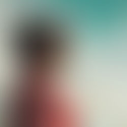 man wearing black cap with eyes closed under cloudy sky