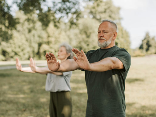 A Mature Couple Doing Yoga with Their Arms Outstretched