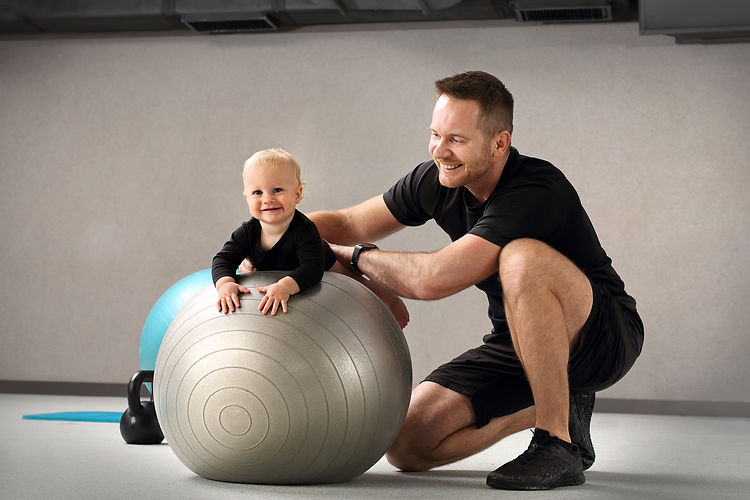 Physiotherapy and rehabilitation of a child. Physiotherapist exercises with a baby on a ba
