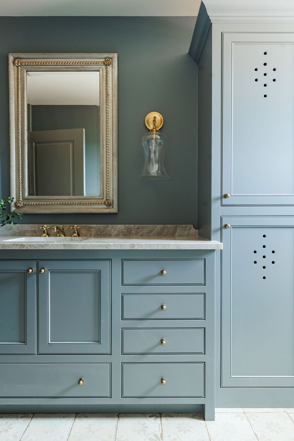 Elegant bathroom vanity with blue cabinets and gold accents.