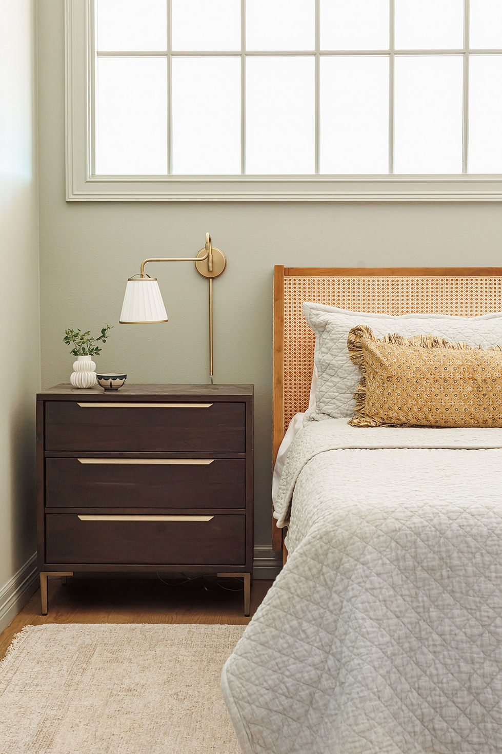 Bedroom with nightstand, bed, and wall lamp.