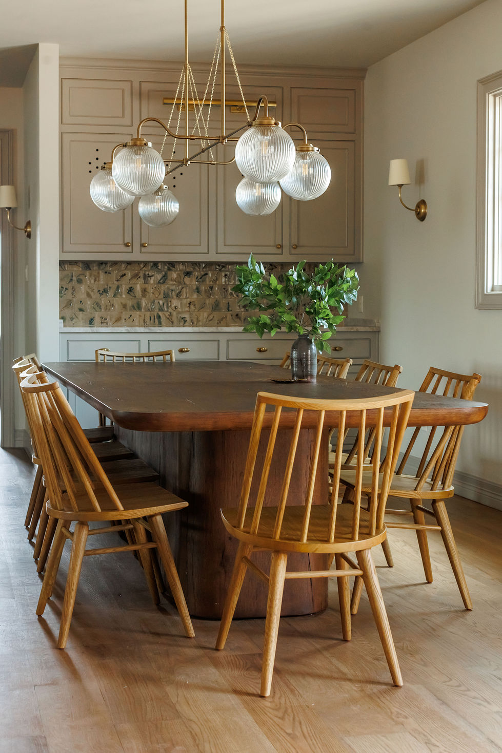 Dining room with wooden table and chairs, modern chandelier.