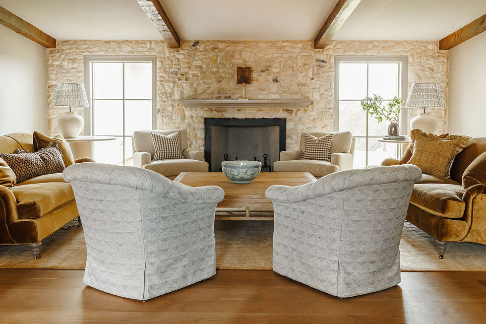 Cozy living room with stone fireplace and armchairs.