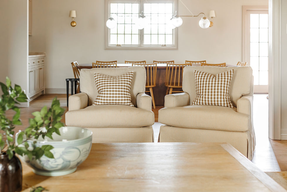 Cozy living room with beige chairs and checkered pillows.