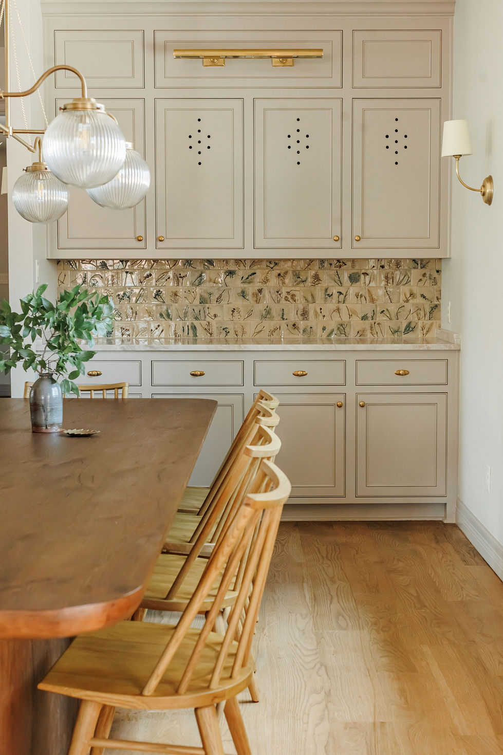 Elegant kitchen with wooden table and floral backsplash.