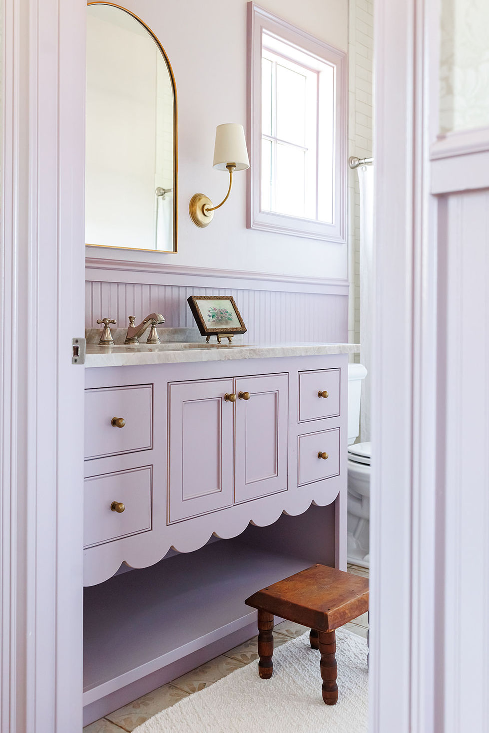 Lavender-themed bathroom with elegant vanity and mirror.