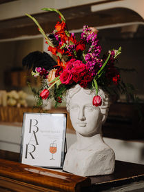 European bust filled with bright florals adds whimsy to the bar decor