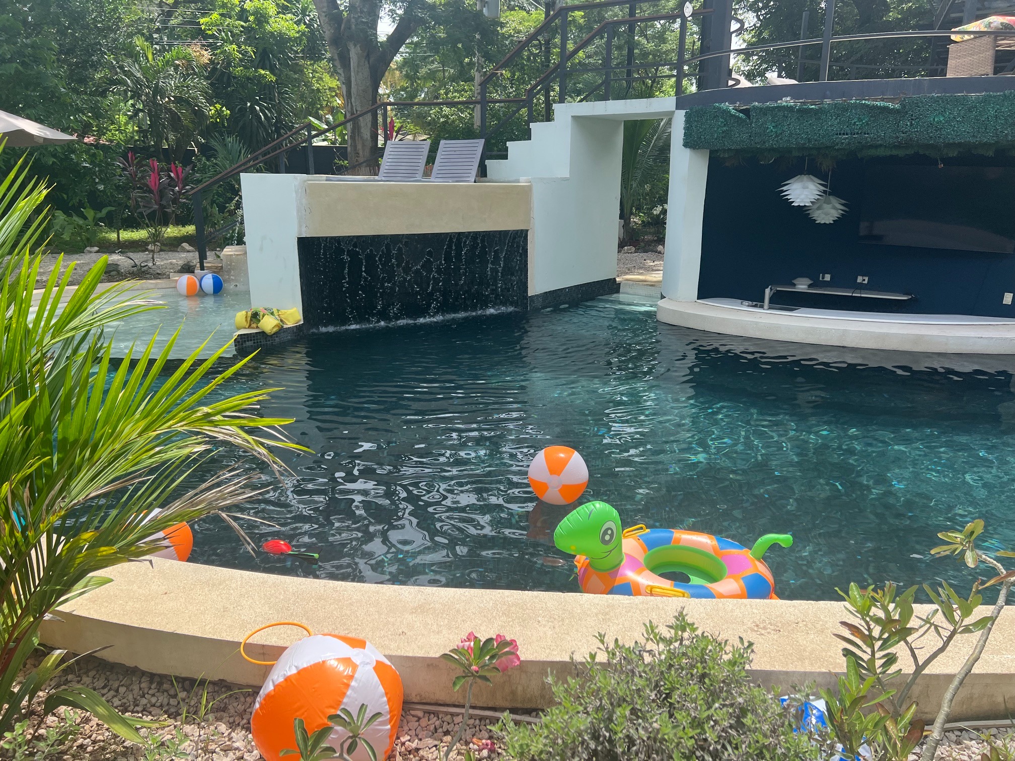 Pool with colorful floats and tropical landscaping