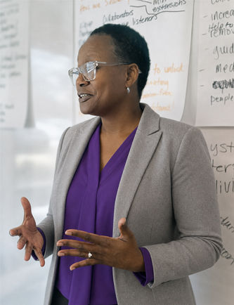 Co-owner Lachandra Baker facilitating a corporate strategy and culture planning session with a client on a whiteboard.