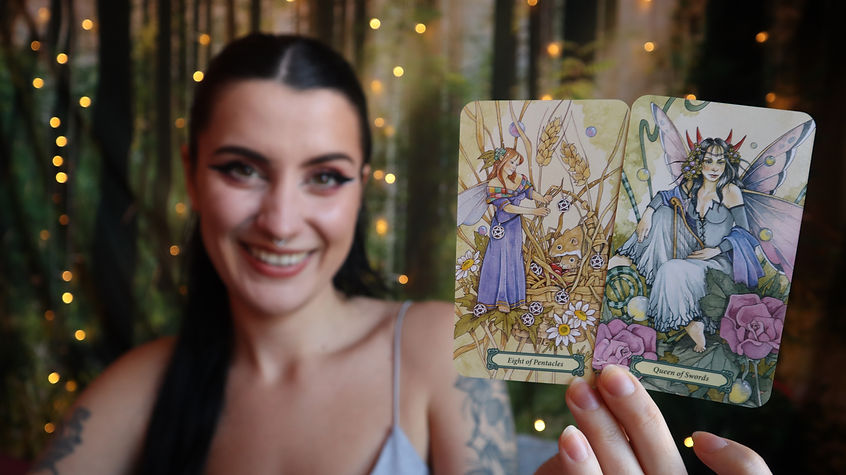 Laura Downs of Spirit Psychic holding up tarot cards and smiling.