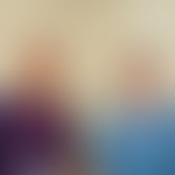 Two people standing side by side, one in a purple NHS polo shirt and the other in blue NHS scrubs.