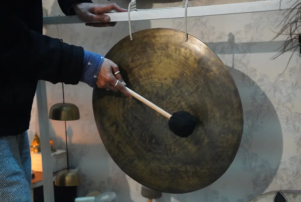 Close-up of a large gong being played with a mallet during a sound healing session at Ananda Dhwani, Rishikesh.