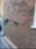 Weatherproof outdoor sockets installed on an exterior brick wall.