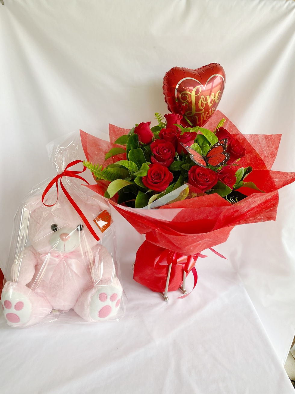 A gift set of a teddy bear, 12 red roses, and a love balloon