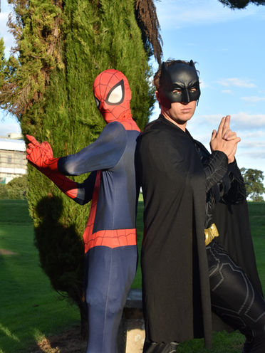 spiderman and batman posing together at superhero birthday party