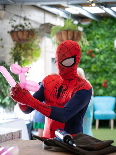 spiderman doing balloon twisting as kids birthday party entertainment