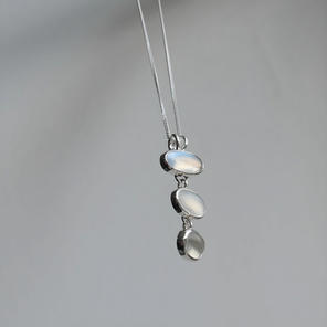 Customers three moonstones, bezel set and linked to form a cascading pendant.