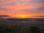 Breathtaking sunset over the Firth of Clyde as seen from Troon, Scotland, with vibrant orange and pink skies reflecting on the water.
