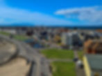 Aerial view of Troon South Beach showcasing the promenade, park, and picturesque coastal townscape with the Isle of Arran in the background.