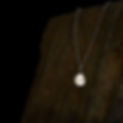 The Aether Pendant - a recycled silver textured pendant, hanging on a rock plinth