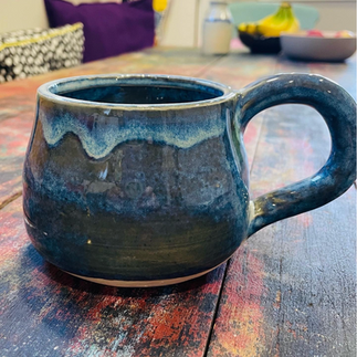 Blue glazed ceramic mug on wooden table