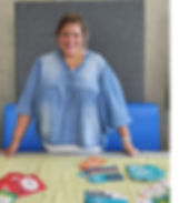 Lisa Miles, Volunteer Development Manager at ACT standing in front of a table with various ACT services leaflets