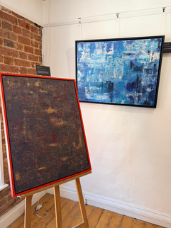 Two abstract paintings; one wall mounted, the other on a wooden easel