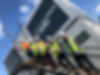 Five men in hard hats and high vis jackets, standing on the steps of a staircase leading to site offices. The sign on the side of the site office reads: "St. Modwen Homes".