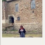 person sewing in front of a medieval castle