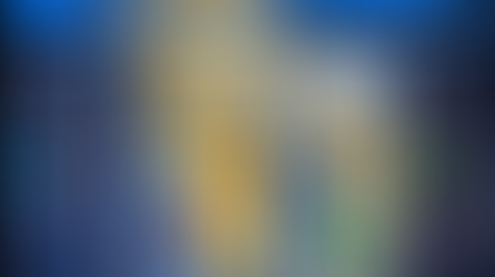 entrance to a building with a white porch and a defibrulator to the left of the door. It's dusk and the lights are on inside the building