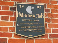 A black and gold plaque, in the shape of a shield, commemorating the restoration