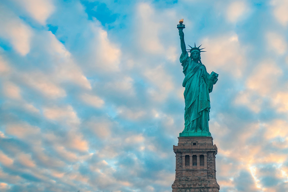 statue of liberty against blue sky with clouds
