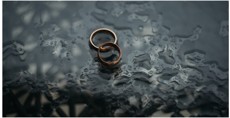 two wedding rings in puddle of water