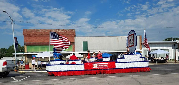 Parade float entry with American flags and people riding on it in the parade 2025. Altamont Flag Day is June 13, 2026.