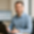 Smiling man working on laptop with charts in the background, Blaak Administratie