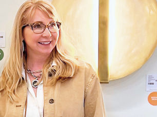 Stylish designer against a white wall, accompanied by two, large, bronze lights